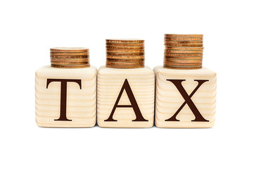 Stacks of coins and wooden cubes with word "Tax" on white background.