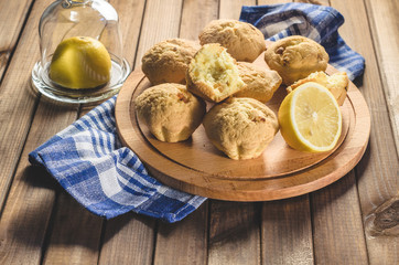 Lemon cupcakes on a wooden Board on the table with a blue towel.
