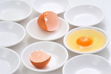 yolks in small bowls  by circle shape repetition in white background.