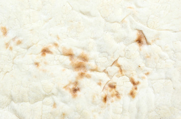 The texture of baked thin flatbread. Macro photo.