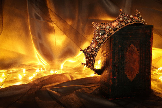 low key image of beautiful queen/king crown on old book. fantasy medieval period.