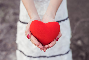 Red heart in hand of young women