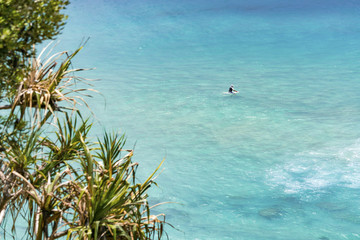 Obraz premium A lone surfer sits on his board at Coolangatta, Gold Coast, Queensland, Australia.
