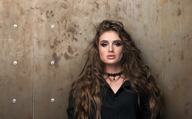 Fototapeta premium Beauty portrait of beautiful young woman with professional makeup standing against the wall