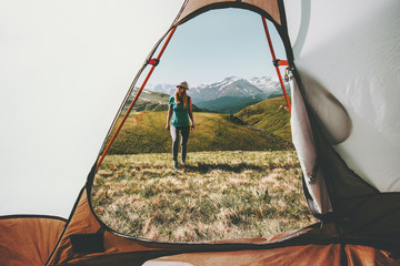 Woman traveler walking in mountains view from tent camping entrance outdoor Travel Lifestyle concept adventure summer vacations outdoor
