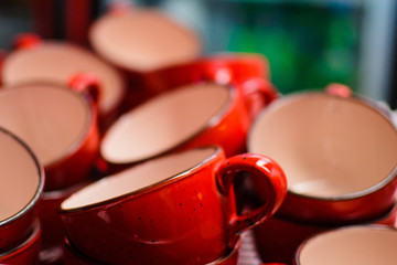 a lot of empty red cups for tea in a cafe