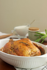 Baked chicken with herbs and garlic, served with sour cream sauce. Rustic style.