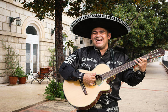 Mexican musician mariachi with guitar on a city street