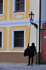 WROCLAW, POLAND, JANUARY 2018: A street lamp lighter lighting up the gas street lamp on Ostrow Tumski