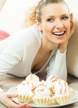 Cheerful smiling woman with plate of cakes