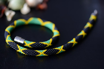 Bright beaded jamaican necklace on a dark background close up
