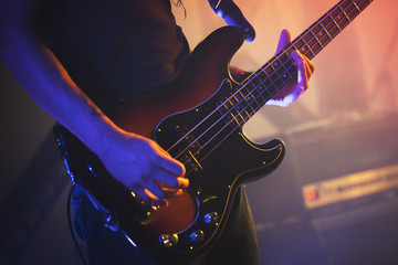 Electric bass guitar player, close up photo - obrazy, fototapety, plakaty