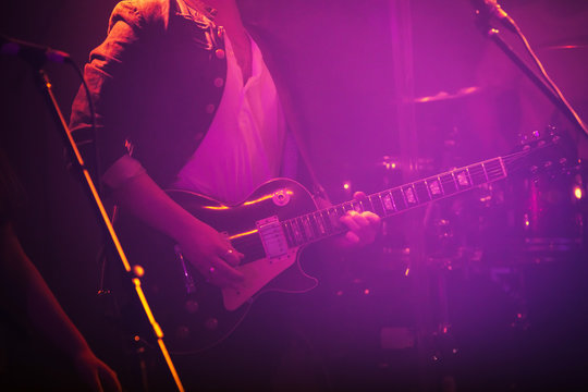 Electric guitar player in purple light