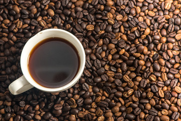 A white cup of coffee with coffee bean background