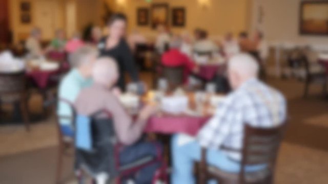 Seniors eating their lunch in an assisted living center dining room