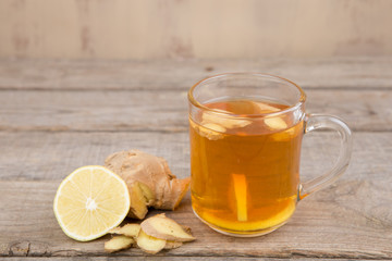 Ginger tea in a cup on wooden background