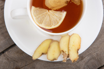 Ginger tea in a cup on wooden background