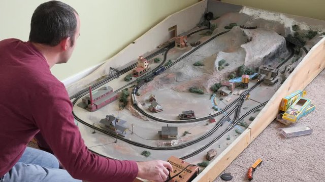 Timelapse of man playing with replica model train set