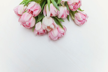 Bouquet of pink tulips over shabby white wooden table. Spring greeting card happy mother day copy space