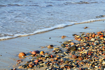 Colorful pebbles and surf on the Baltic sea