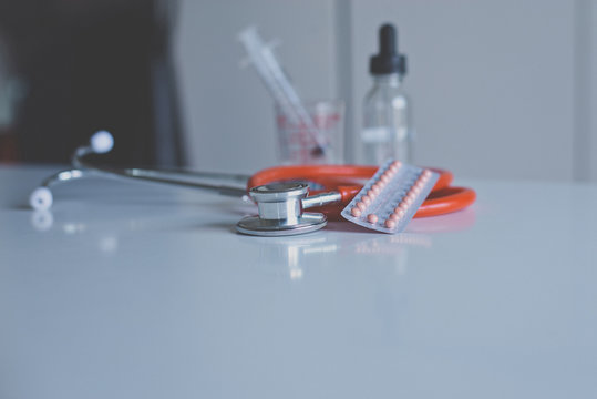 Stethoscope red color with birth control pill on deskd,Healthcare and medical concept