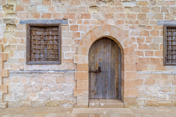 Fototapeta na wymiar Door and two windows of one of the rooms surrounding the main yard of the citadel of Alexandria, Egypt
