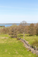 Fototapeta na wymiar Rural landscape view with a lake and a stone wall in early spring