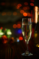 A glass of Sparkling wine in front of defocused colorful lights of dark background 3