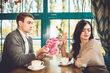 The woman reject a flowers from her boyfriend in the restaurant