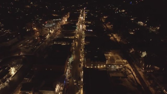 Aerial dolly shot cars in cool little mountain town on a winter night