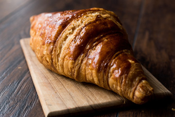Freshly Baked Croissant on Wooden Surface.