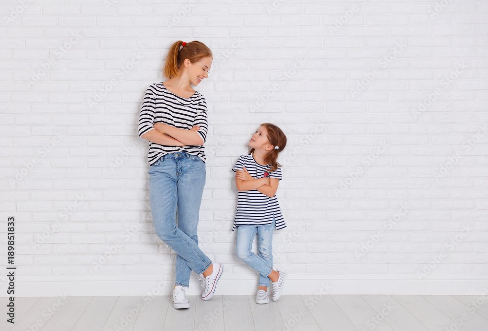 Wall mural happy family mother and child daughter near an empty wall