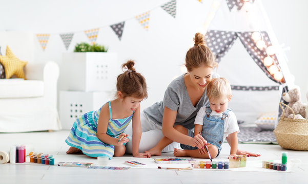 children's creativity. mother and children draw paints in   playroom