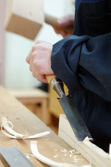 A carpenter planing a piece of wood.