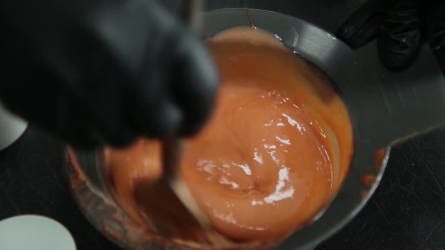 Hair Dye Preparation, Colorist Stirs With A Brush Red Dye, Beauty Salon Concept