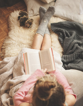 Coziness At Home, Girl Doing Hygge With Book And Warm Blanket