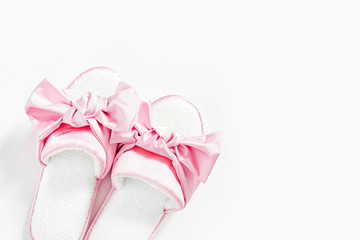 Stylid female slippers with bow on a white background. Flat lay, top view