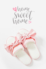 Stylid female slippers with bow on a white background. Flat lay, top view