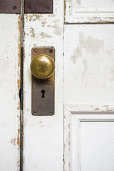 真鍮のドアノブと鍵穴のある白いドア