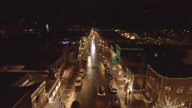 Aerial of cars on road in mountain town at night at winter