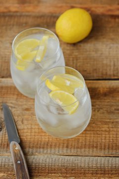 Fresh lemonade with ice and lemon on the table 