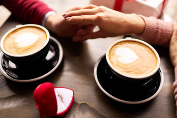 Will you marry me? Valentine's Day concept. Happy couple in love with. A young loving couple celebrating Valentine's Day in the restaurant. Lovers give each other gifts.
