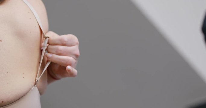 Woman putting on her bra