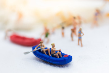 Fototapeta na wymiar Miniature people : Travelers with paddle boat . Image use for activities, travel business concept.