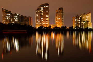 Fototapeta premium night city with reflection of houses in the river