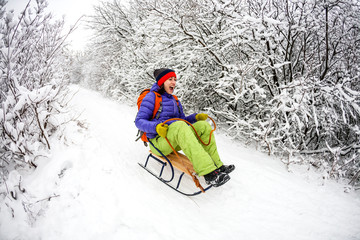 A girl on a sled rides from the mountain.