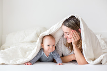 Mother and her little baby boy, playing together in bedrroom © Tomsickova