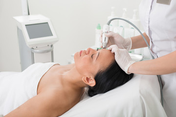 Pleased senior female relaxing in beauty salon. Woman is lying on the couch while doctor taking...