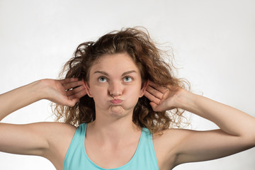 Obraz premium Beautiful girl model croaks funny faces and grimaces on a white background