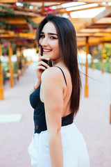 Fototapeta premium Fashion stylish trendy sensual portrait of pretty young woman posing outdoor in summer in the beach cafe having fun alone